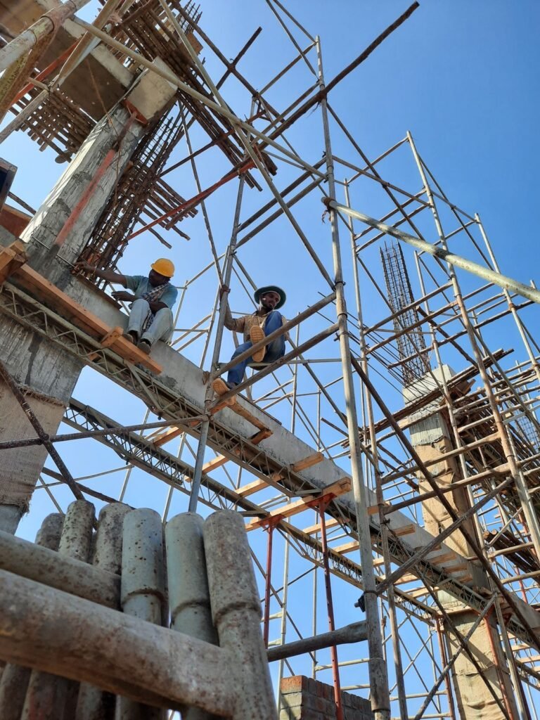 Obreros trabajando sobre un andamio de madera en una obra de construcción