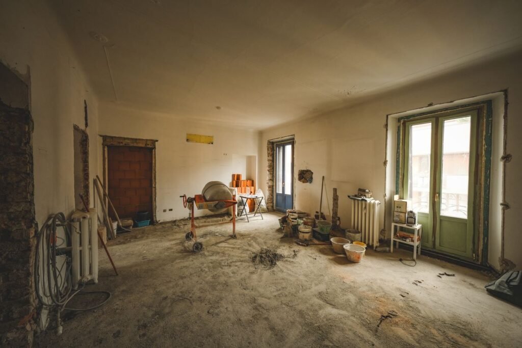 Interior de una vivienda recién construida con polvo y restos de obra sobre el piso