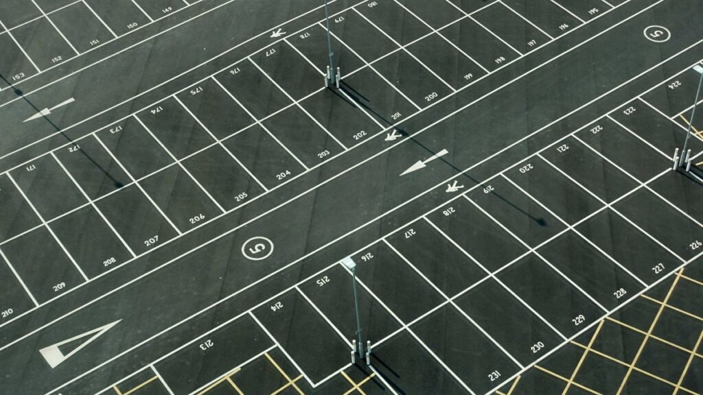 Vista aérea de una playa de estacionamiento pavimentada con demarcación vial, superficie típica de barrido mecanizado