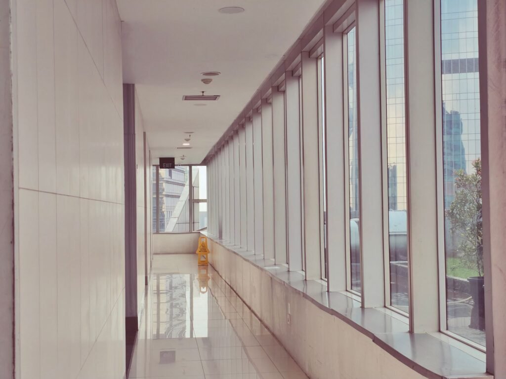 Pasillo de oficinas con ventanales y piso brillante